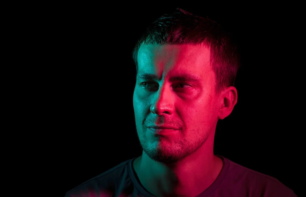 man looking away with stubble in the dark