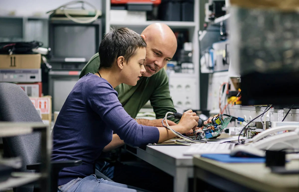 Two Technicians Working On Conductor Board