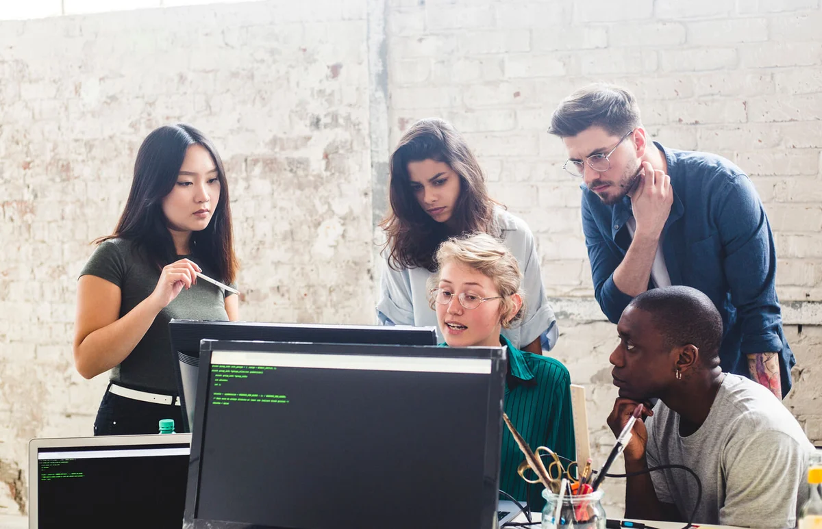 Confident young professionals planning while coding in computer at workplace