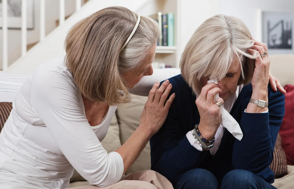 Senior woman comforting crying friend
