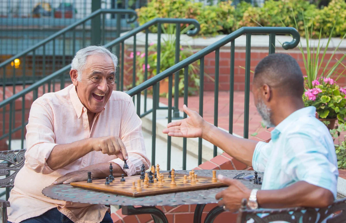 Friends playing chess in garden