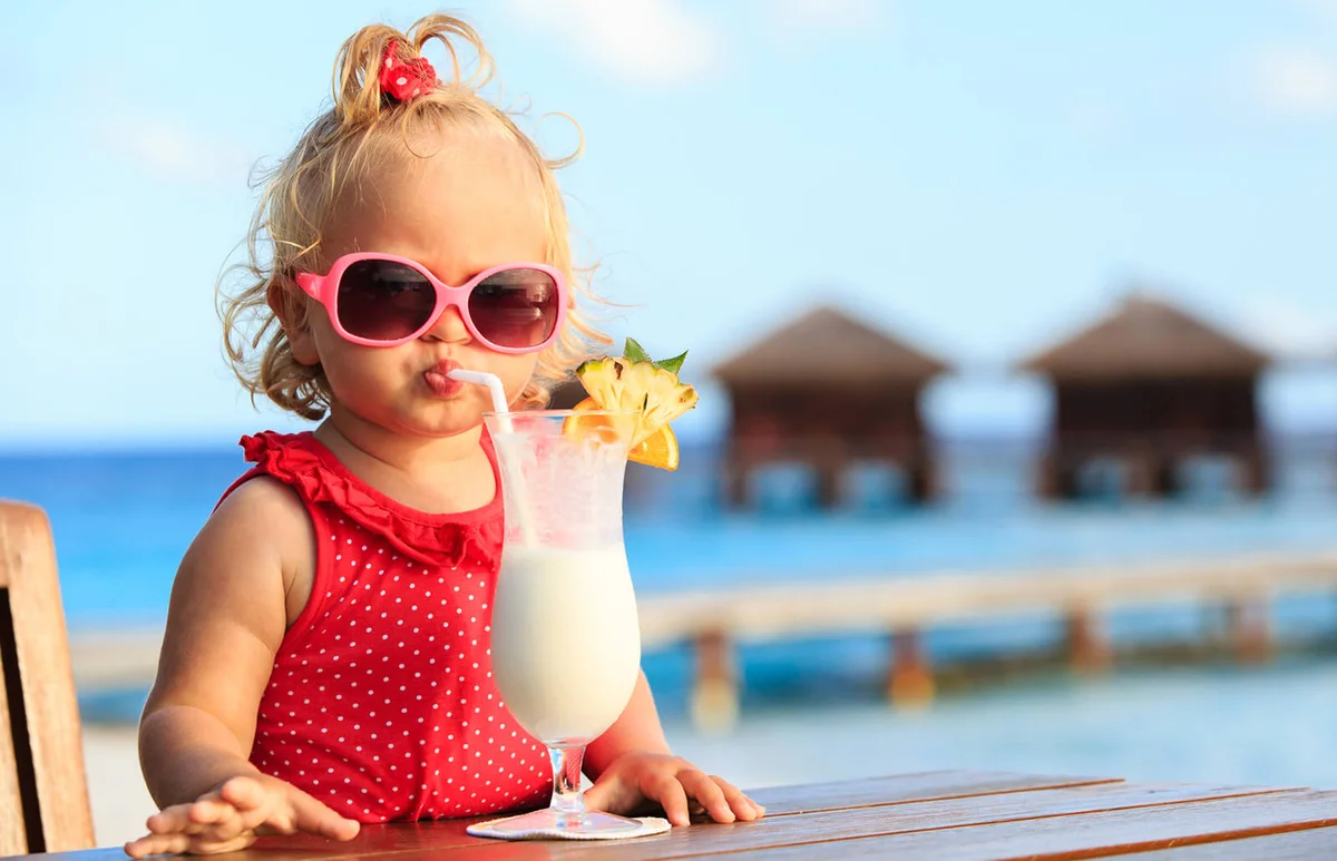 cute little girl drinking frozen slush on tropical beach