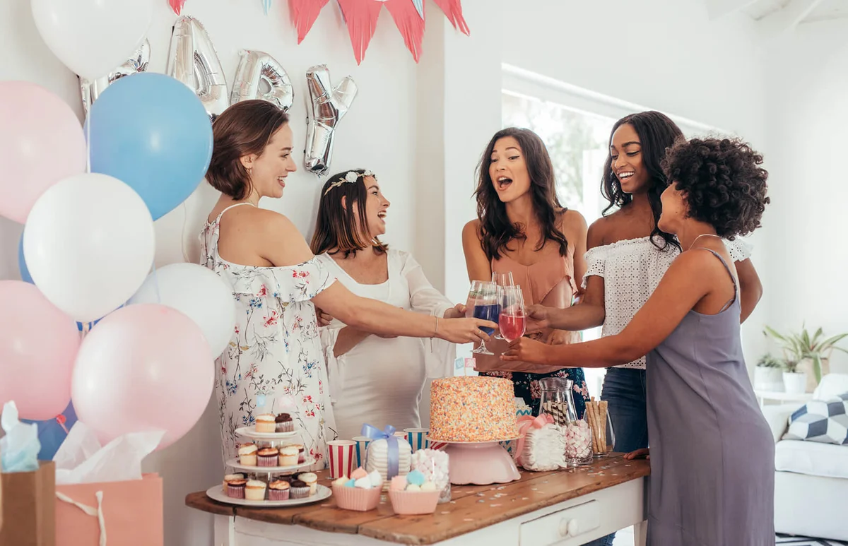 Women toasting with juices at baby shower party