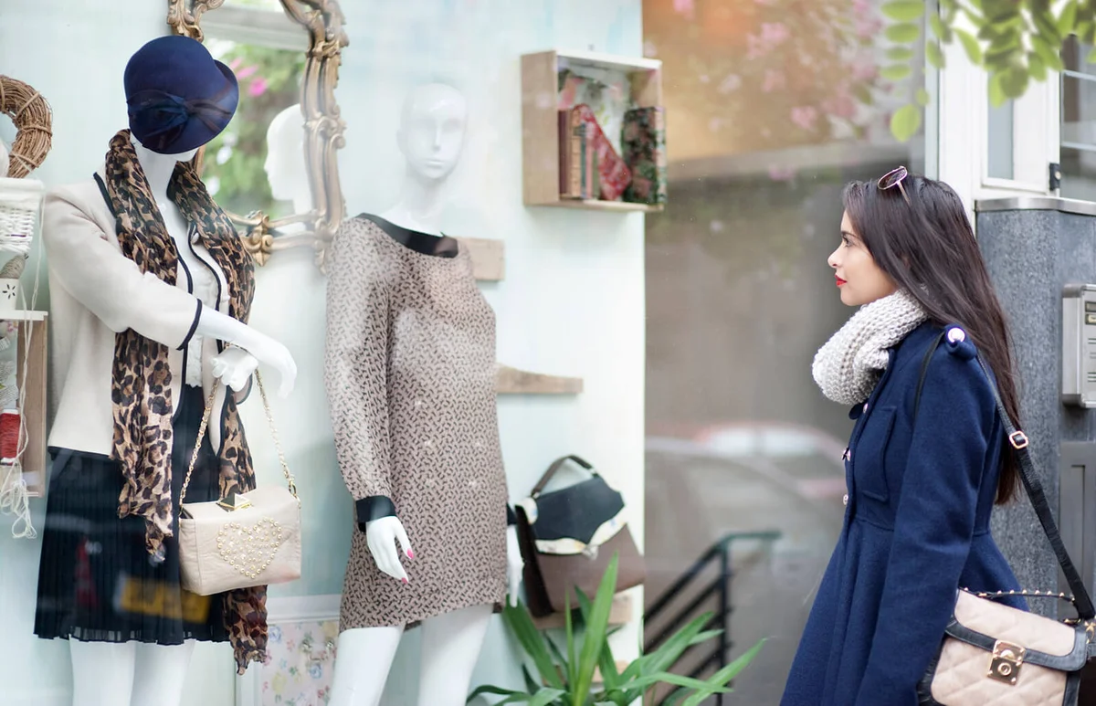 Lady looking at mannequin in window shop