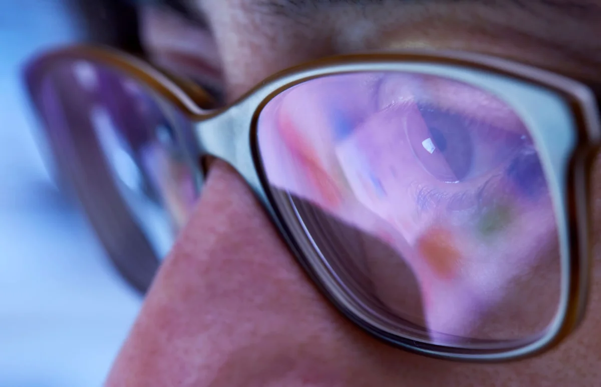 woman with eyeglasses looking to computer monitor