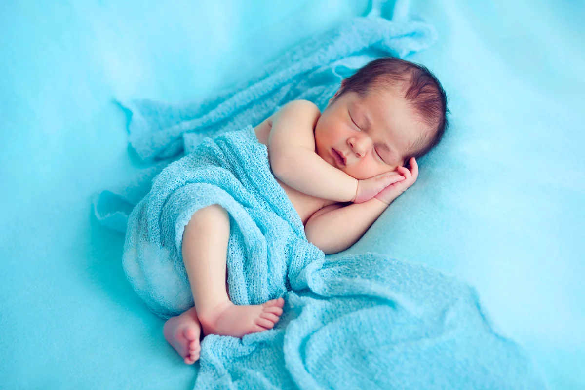 Newborn baby boy in blue wrapped scarf