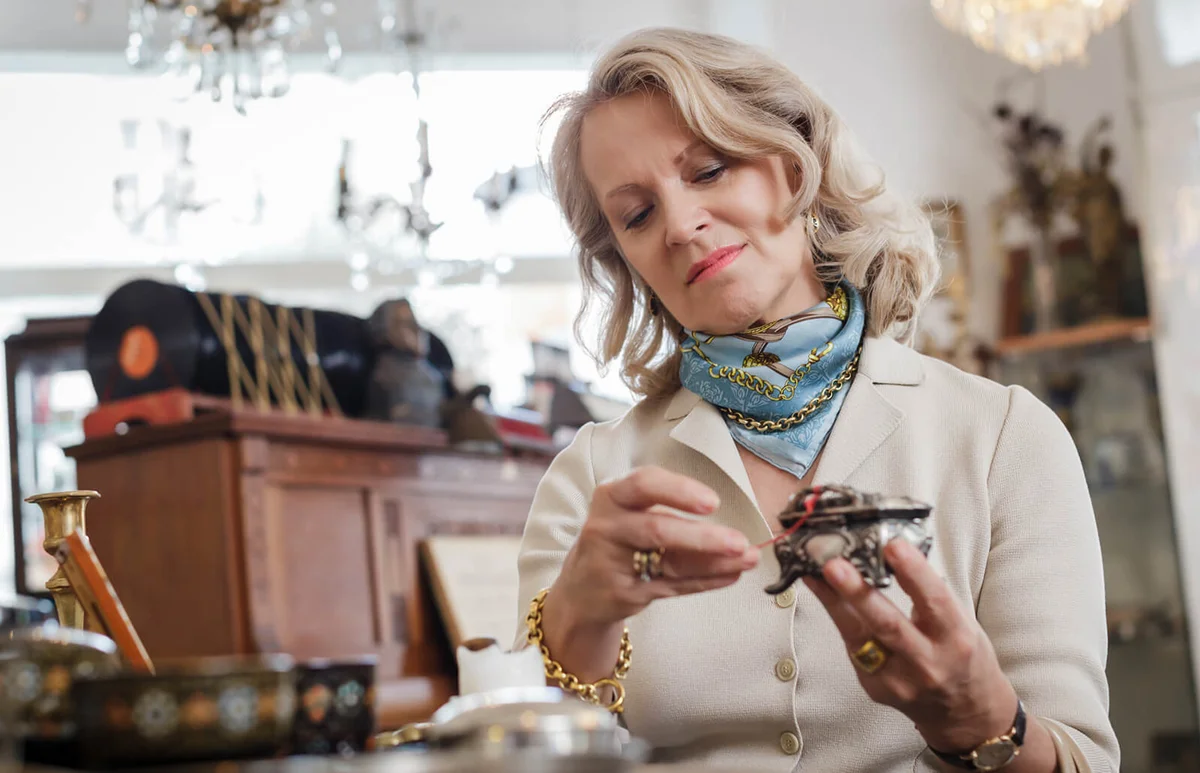 Senior woman checking the price on an antique Item