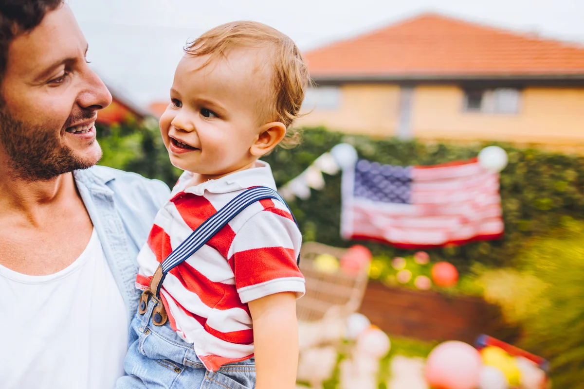 Father and son celebrating Fourth of July in their yard