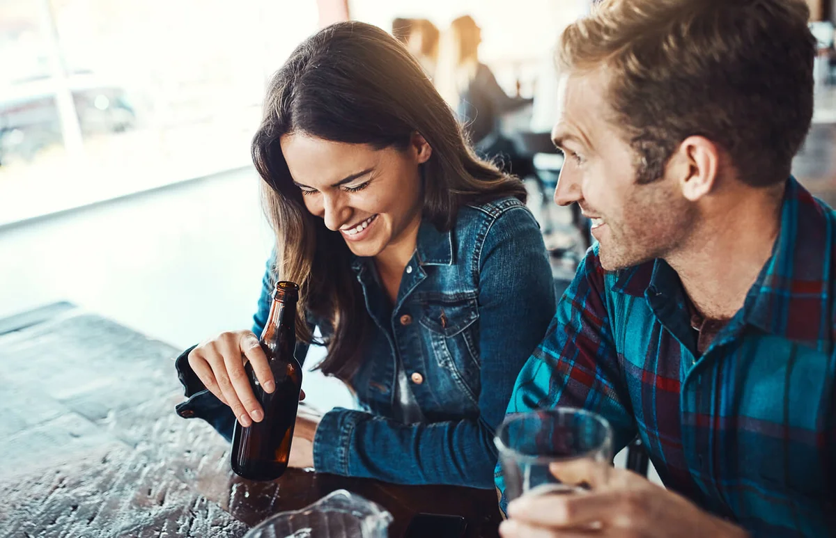 young man and woman having beers at a bar