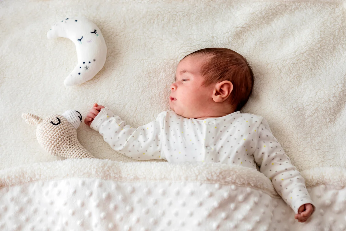 Baby boy in bed sleeping with moon