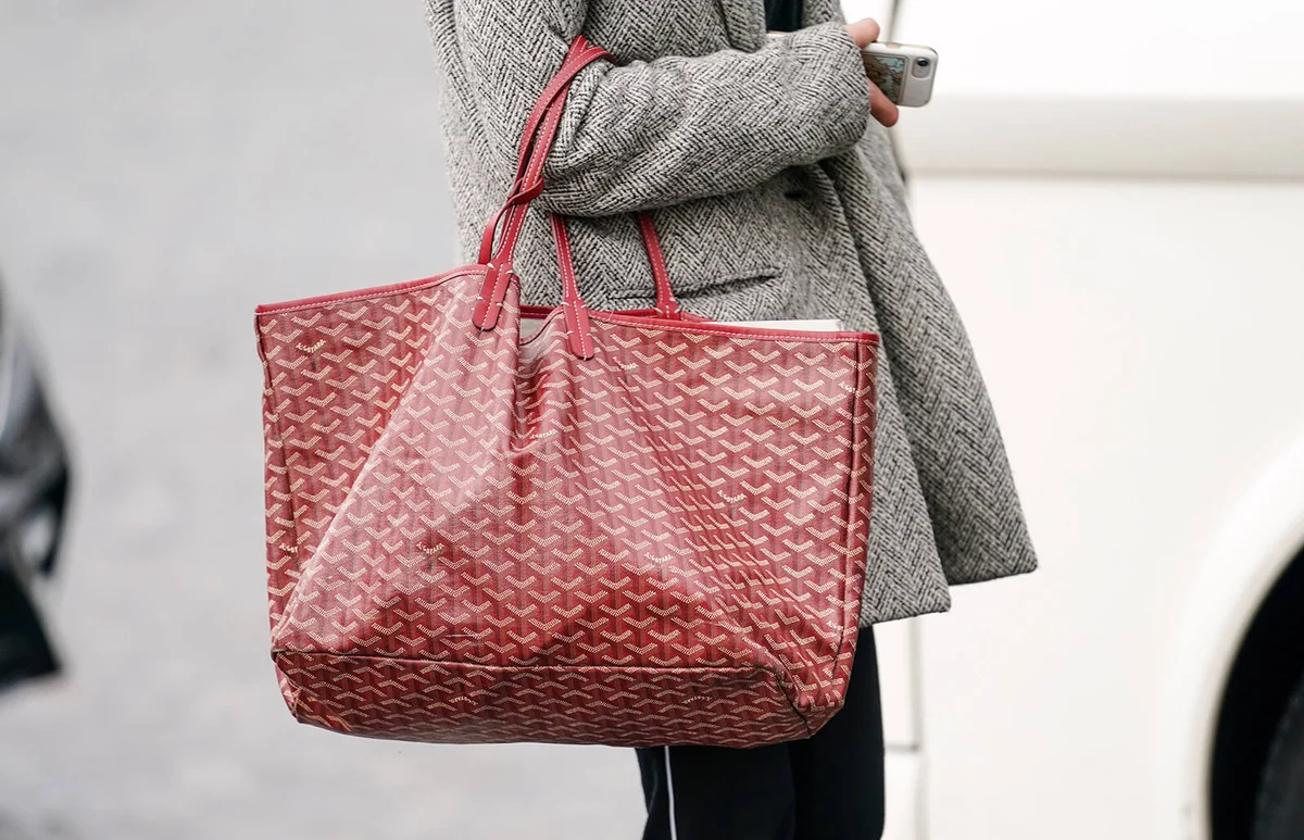 A guest wears a red Goyard monogram large bag | Getty Editorial Use