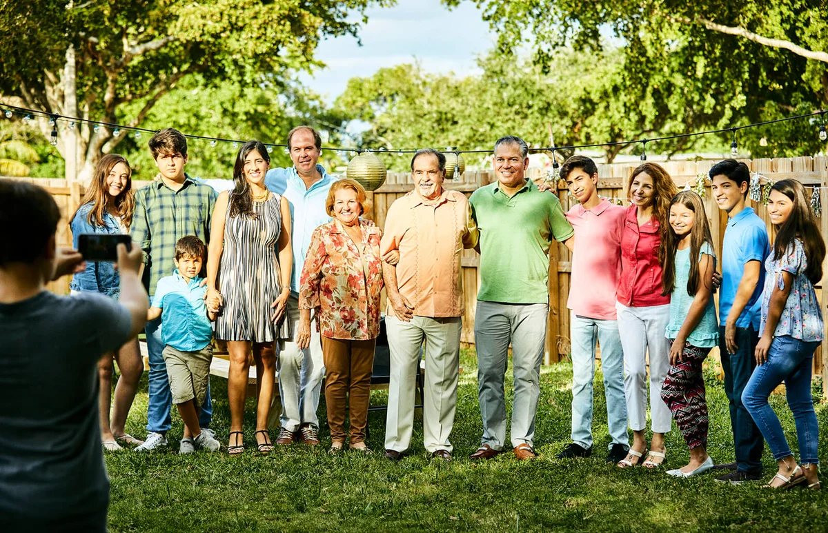 Boy photographing multi-generation family in party