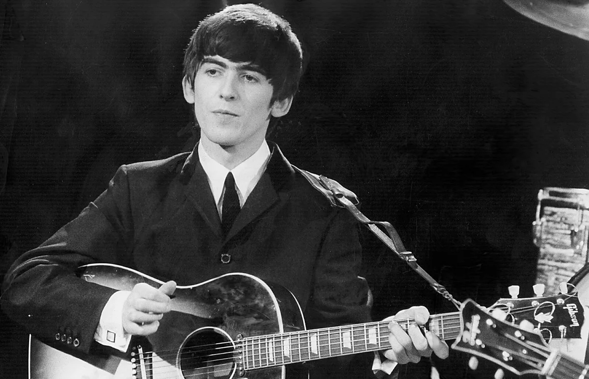Beatles guitarist and singer George Harrison performs December 3, 1963 during a concert | Getty Editorial Use