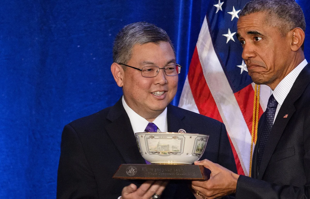 Rep. Mark Takai gives US President Barack Obama a bowl during the House Democratic Issues Conference January 28, 2016 in Baltimore, Maryland | Getty Editorial Use