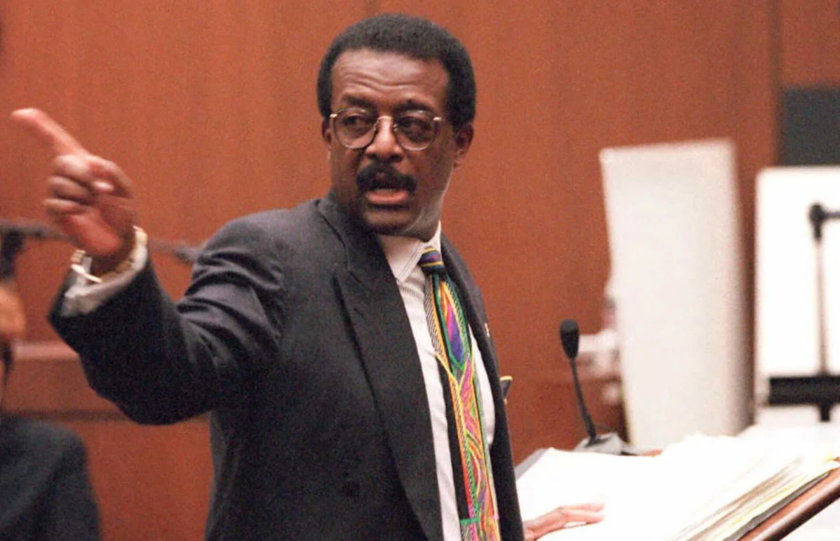 Defense lawyer Johnnie Cochran Jr. points to the door O.J. Simpson | Getty Editorial Use