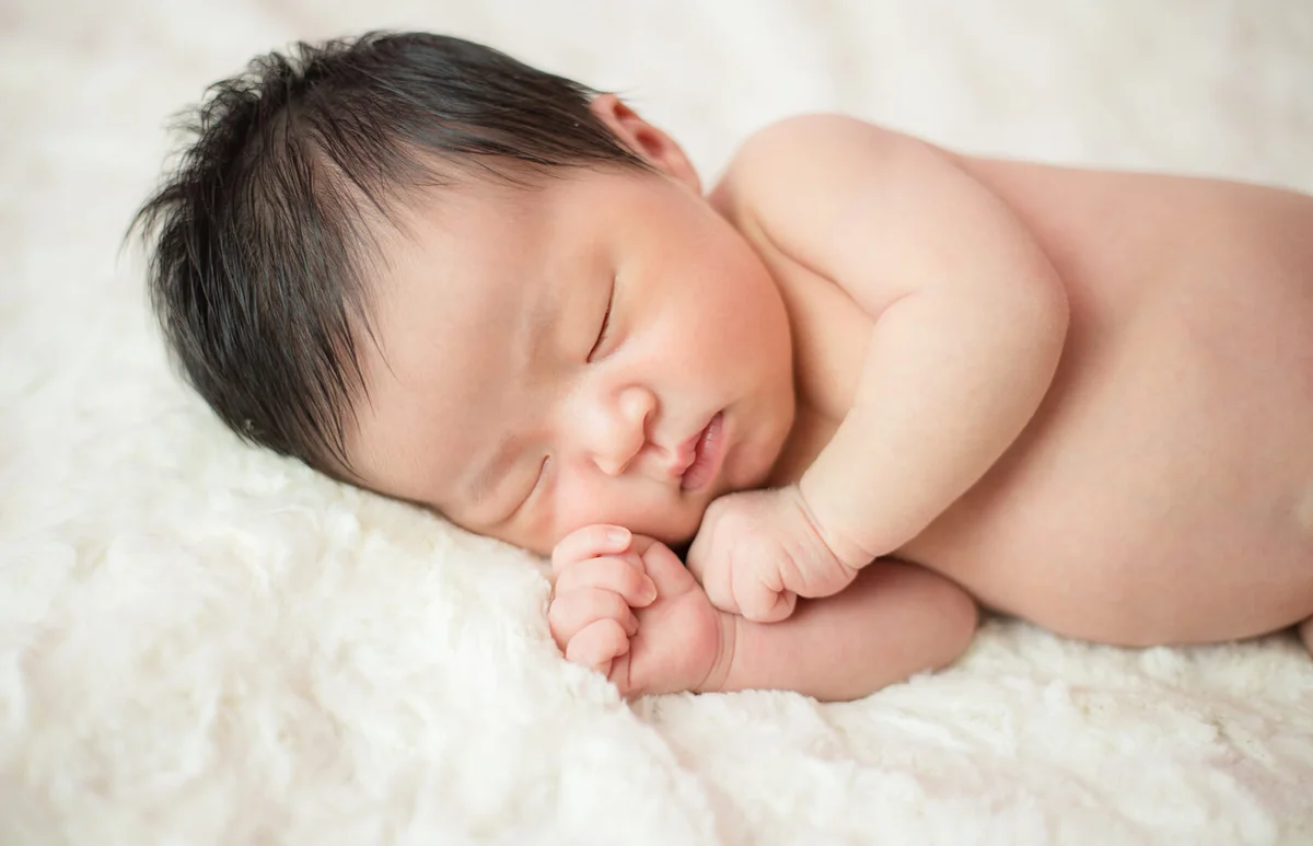 Newborn baby sleeping in bed
