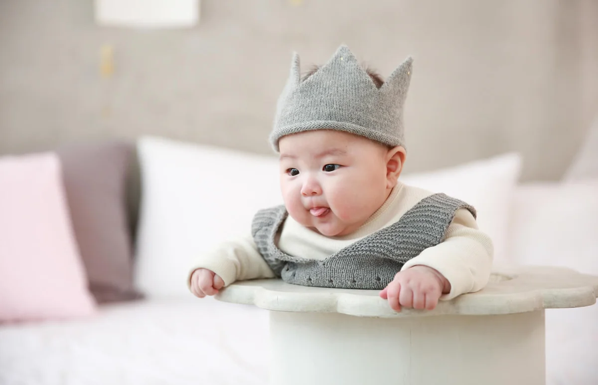 Close-Up Of Cute Baby Boy On Bed At Home