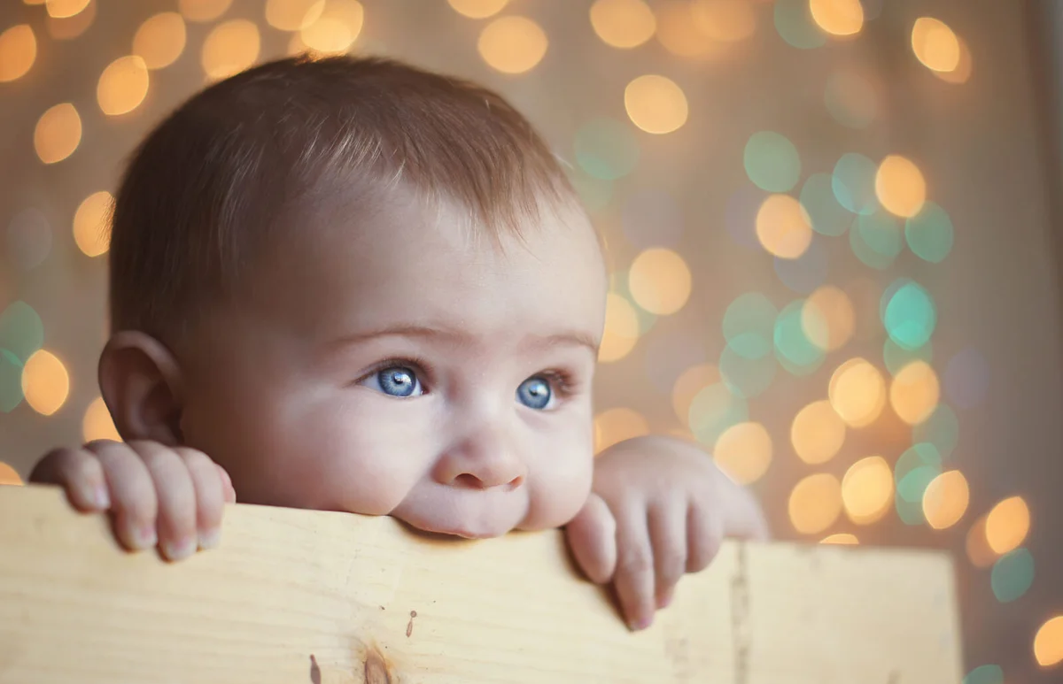 Baby boy chewing on wooden box