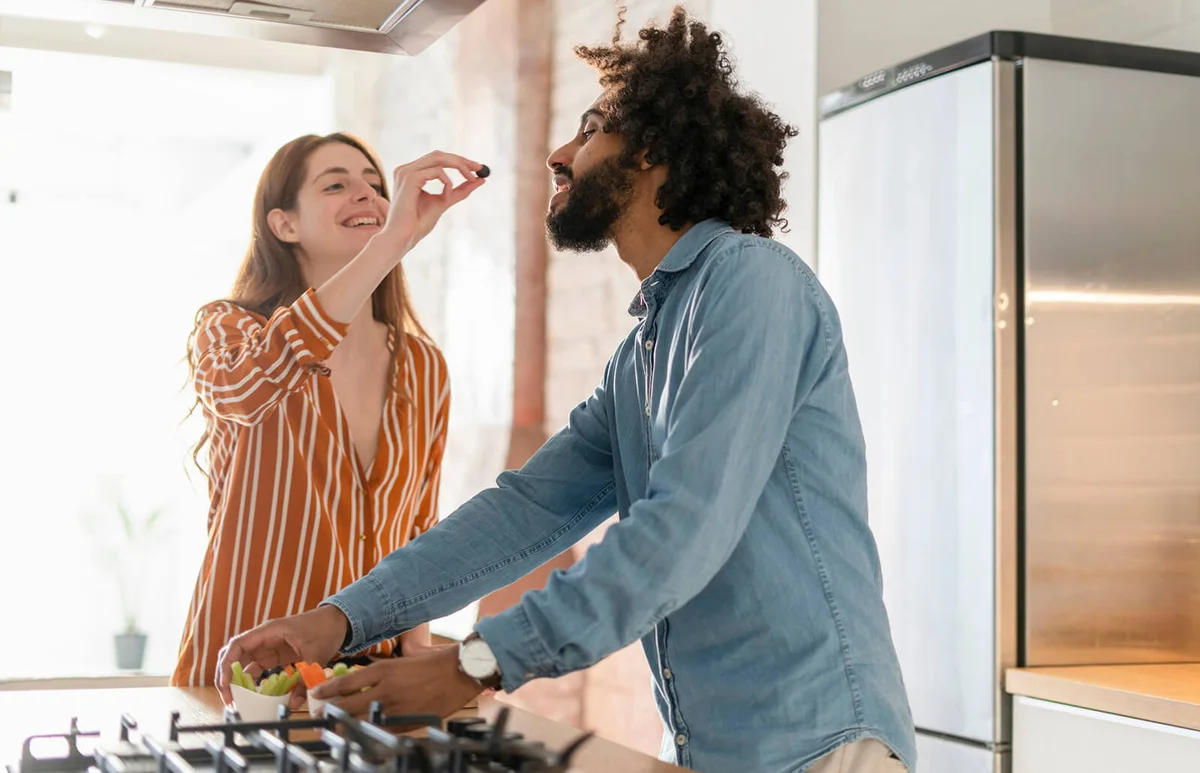 Couple standing in kitchen, preparing dinner party