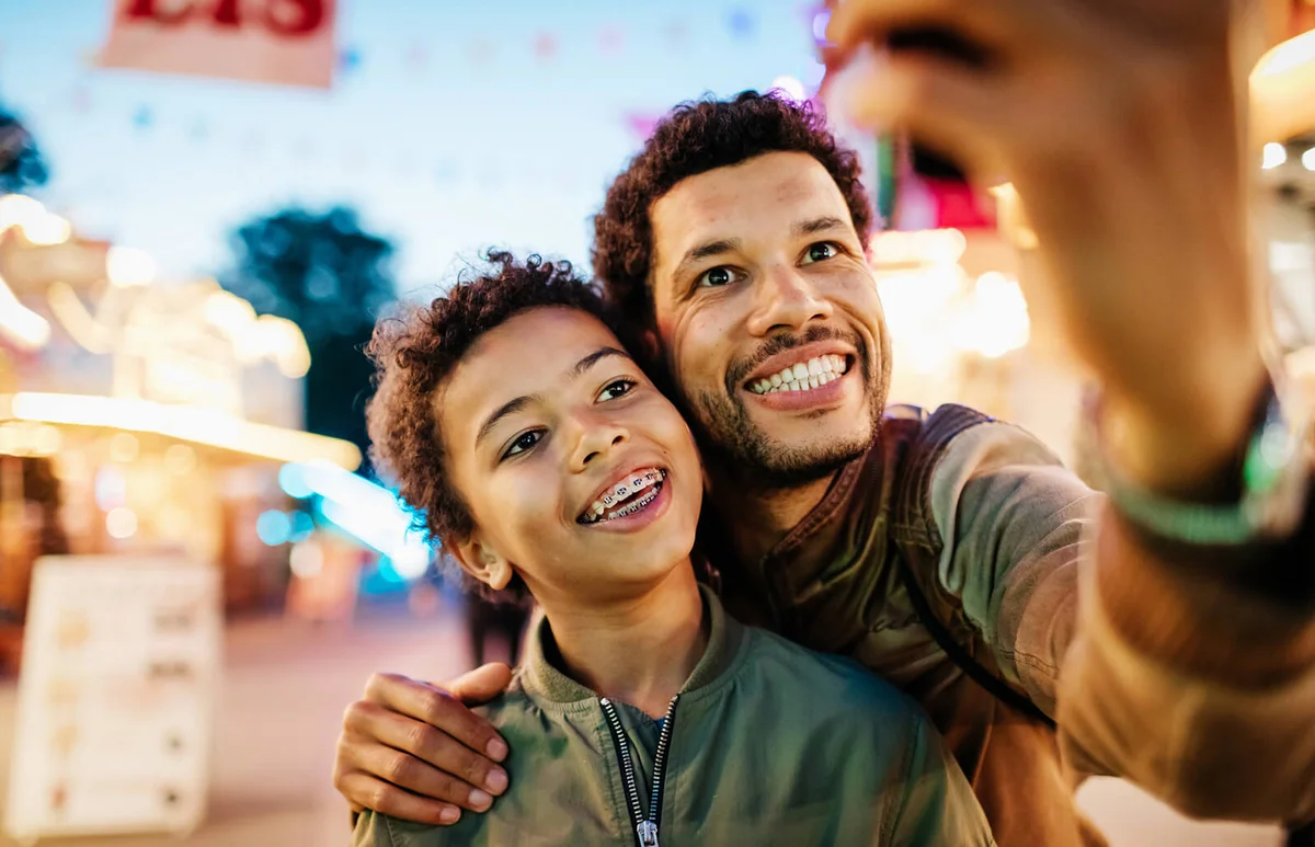 father taking a selfie with his son while out at the fair together
