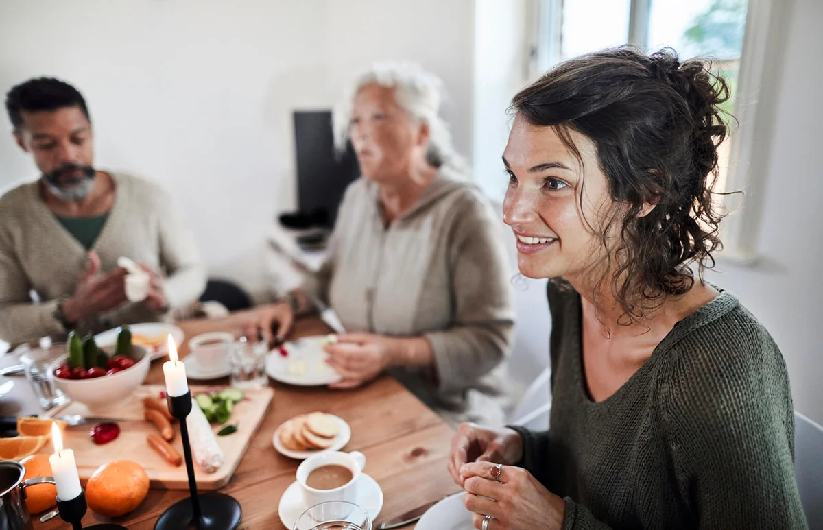 woman having breakfast with family and friends at dining table