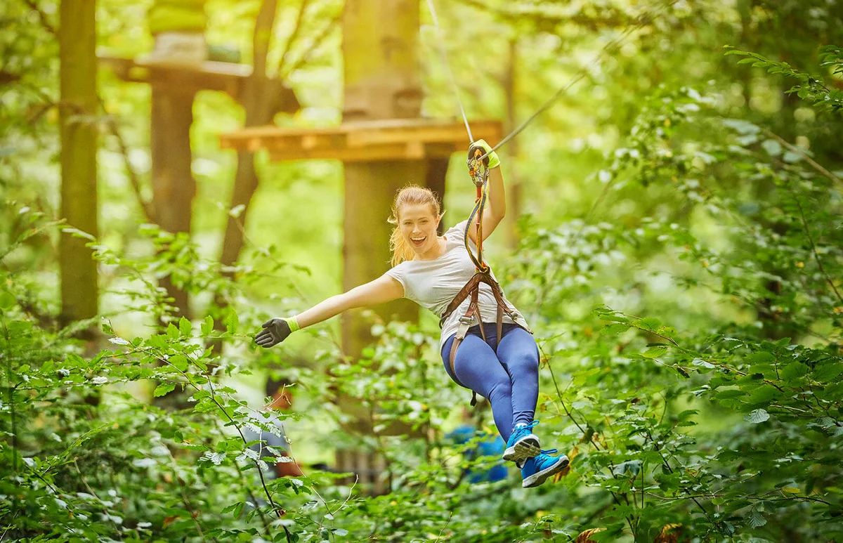 woman enjoy zipping in forest