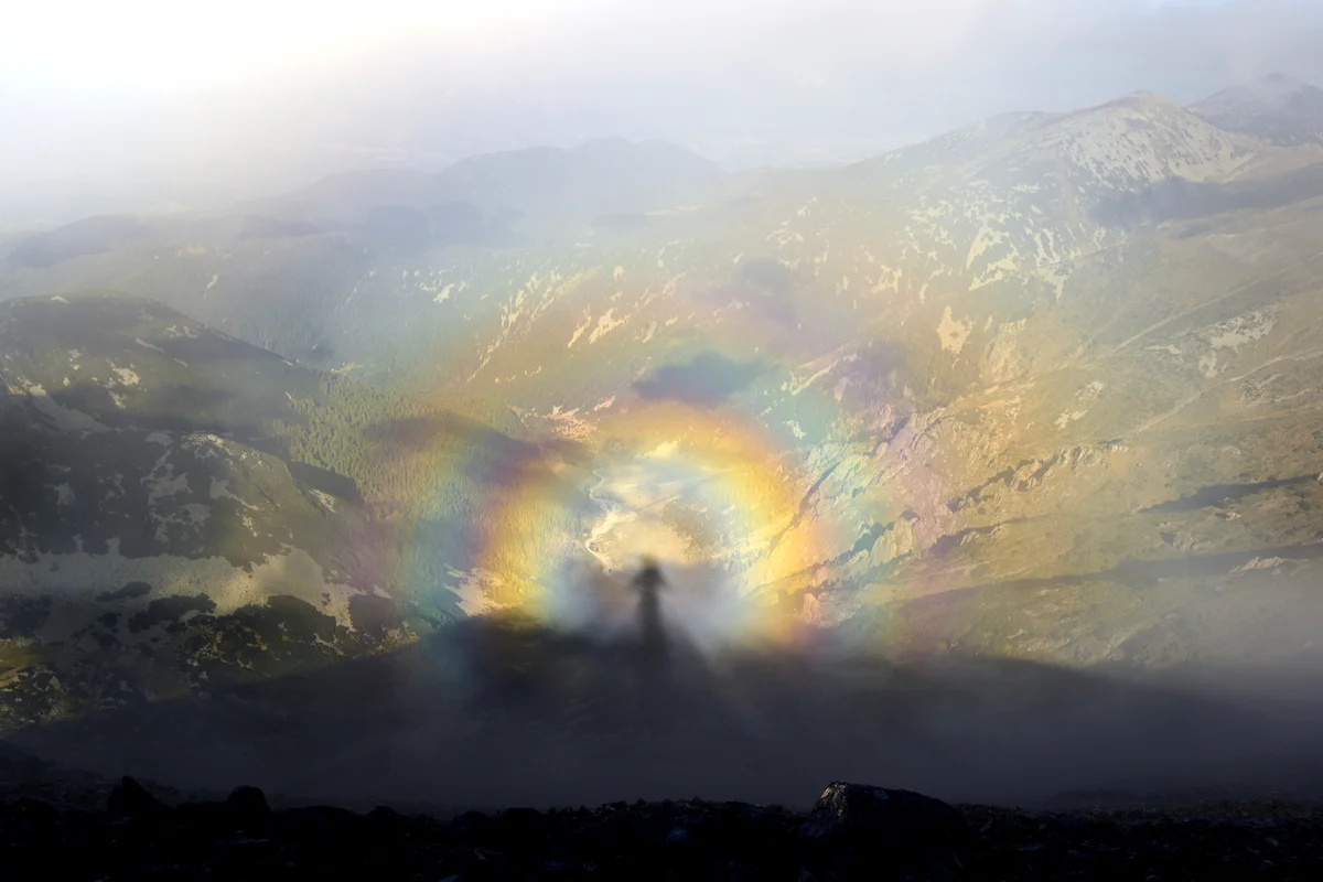 Shadow of a man inside of a rainbow orb