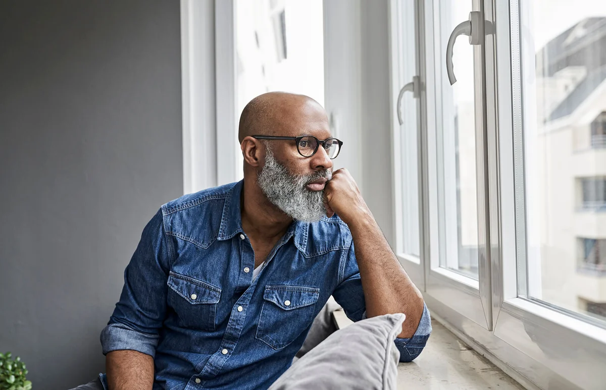 Mature man sitting at window