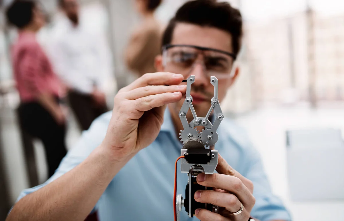 scientist with robotic hand standing in office