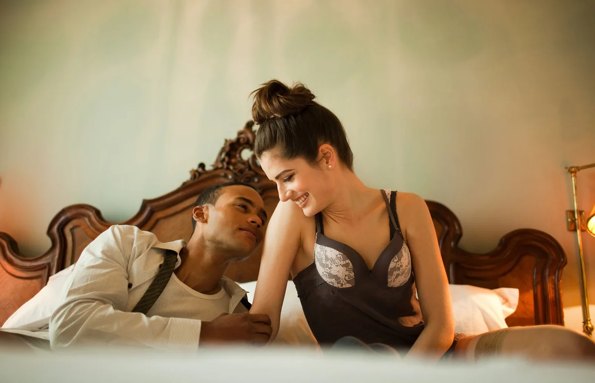 Couple sitting on double bed