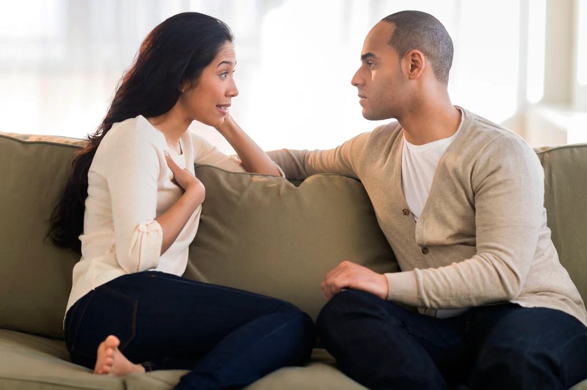 Young couple sitting on couch and having a conversation