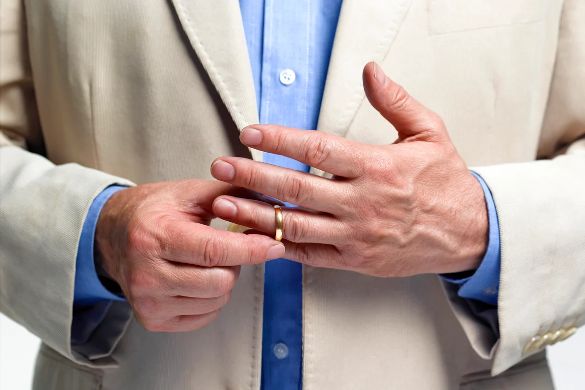 Divorced man taking off wedding ring
