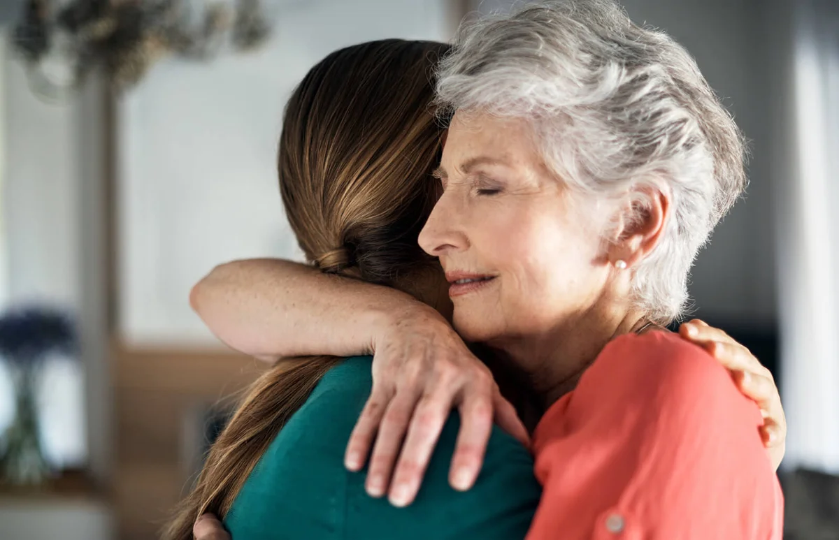 woman embracing her daughter at home
