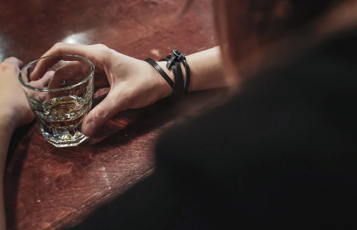 Woman drinking a shot of whisky in a bar