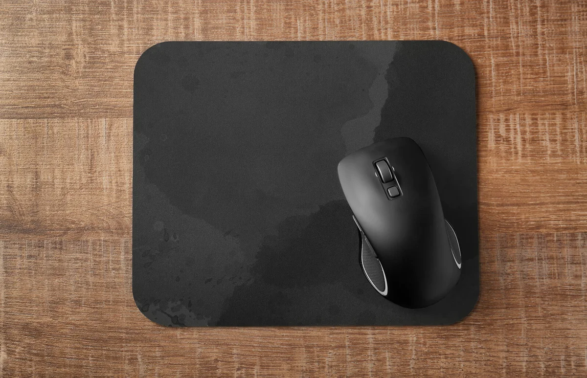 Pad with computer mouse on wooden table