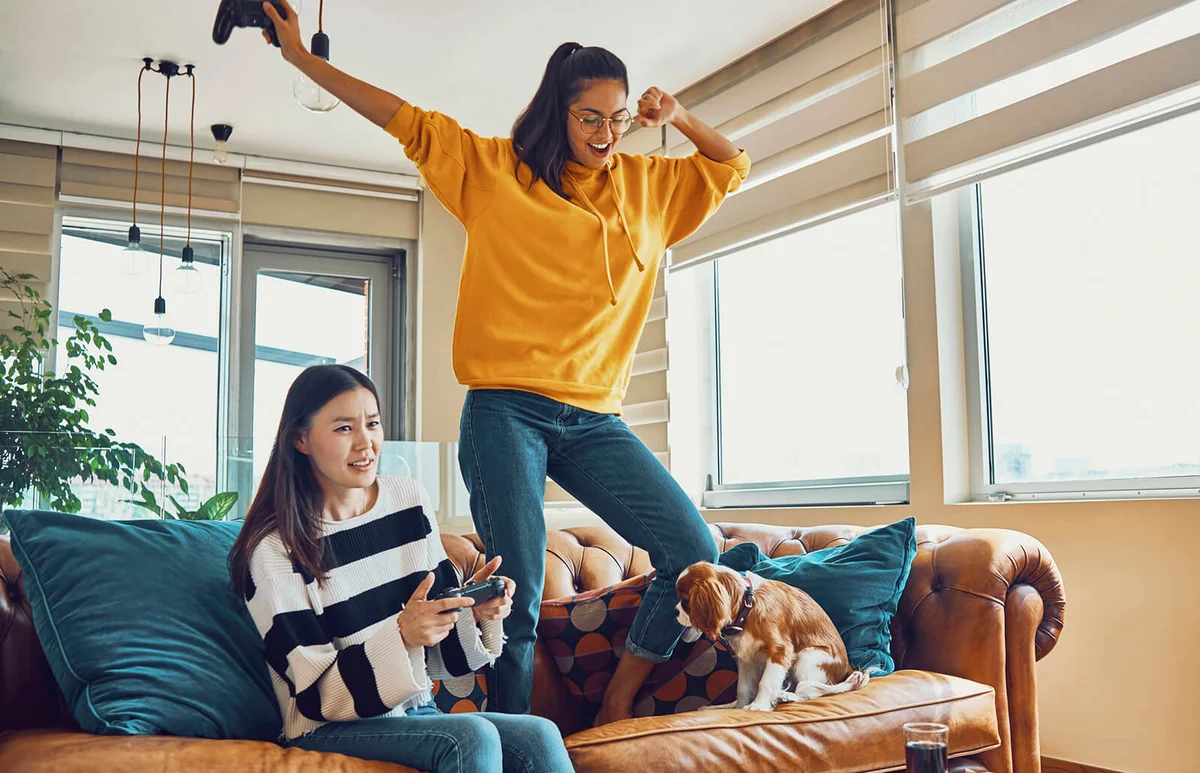 playful friends having fun playing video games at home