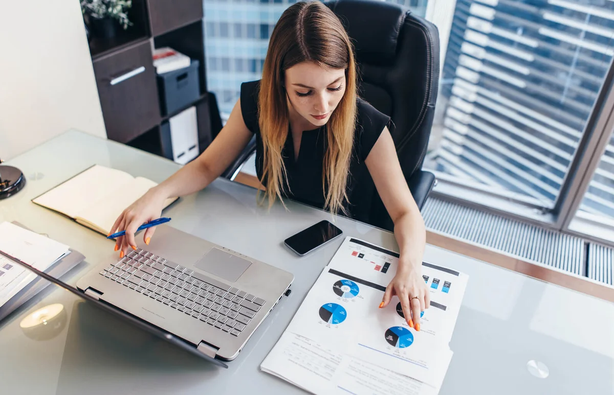 Female businesswoman reading financial report analyzing statistics
