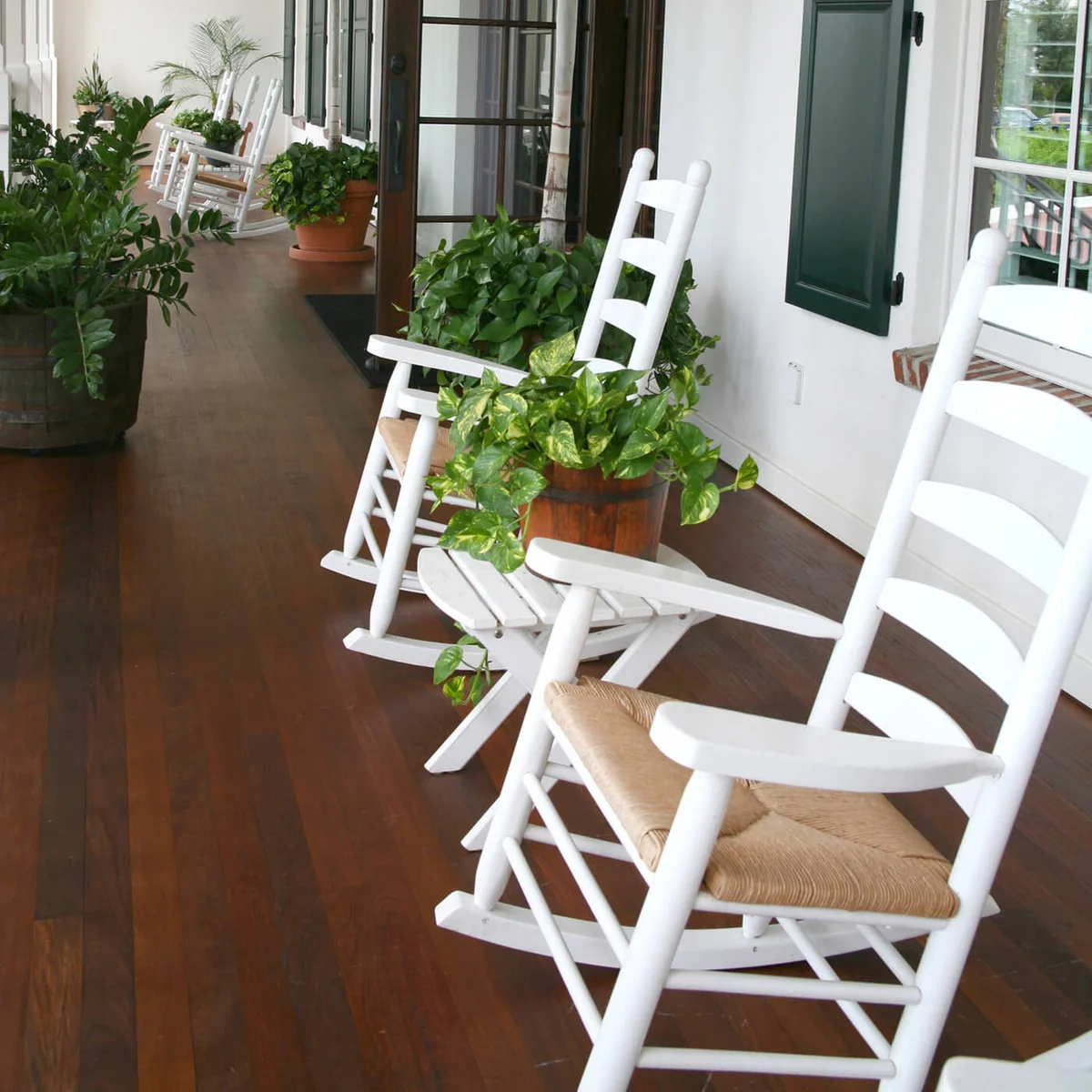 Traditional porch with wooden rocking chairs and palm trees