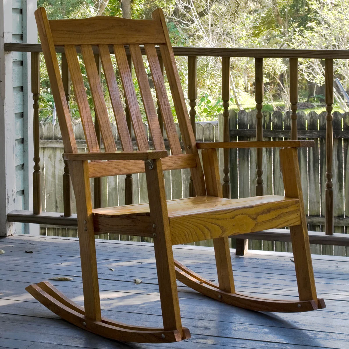 Old wooden rocking chair sitting on a porch