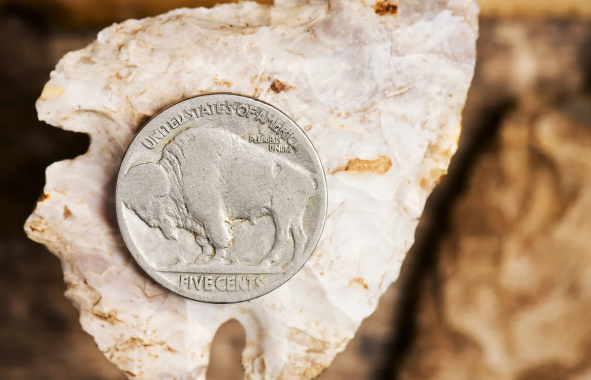An old Buffalo Nickle on an arrowhead