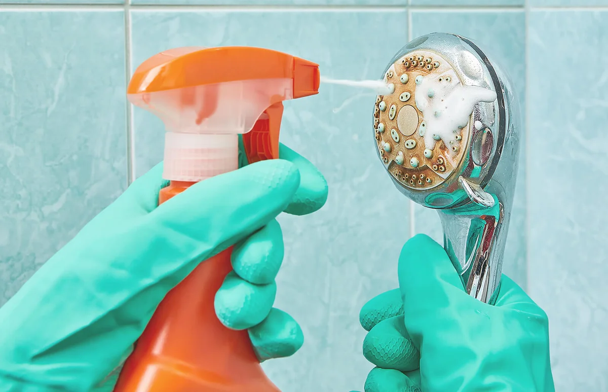 Cleaning the head of shower with a foamy liquid