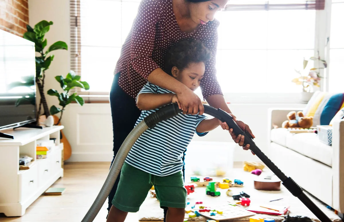 Son helping his mother clean the room