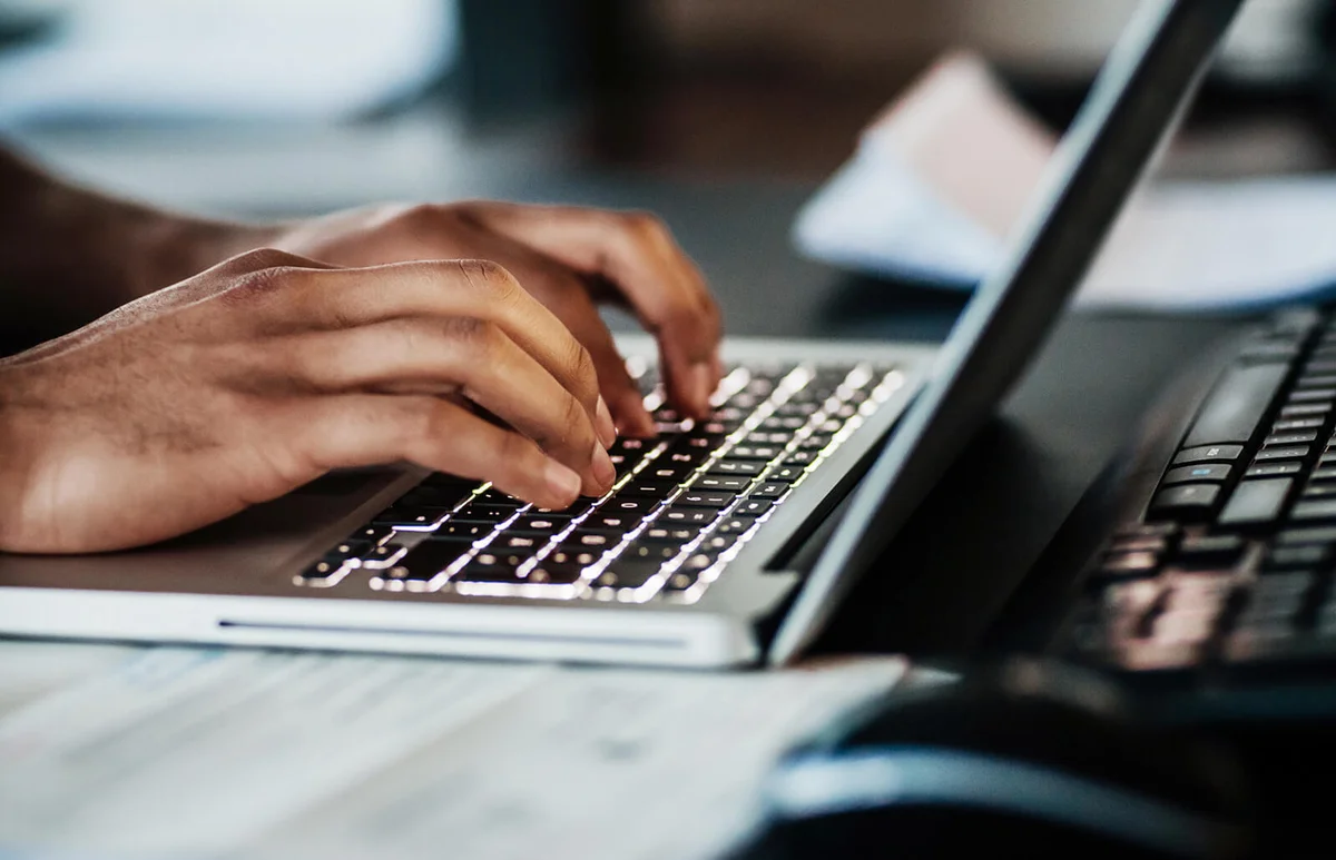 man typing on his laptop at the office