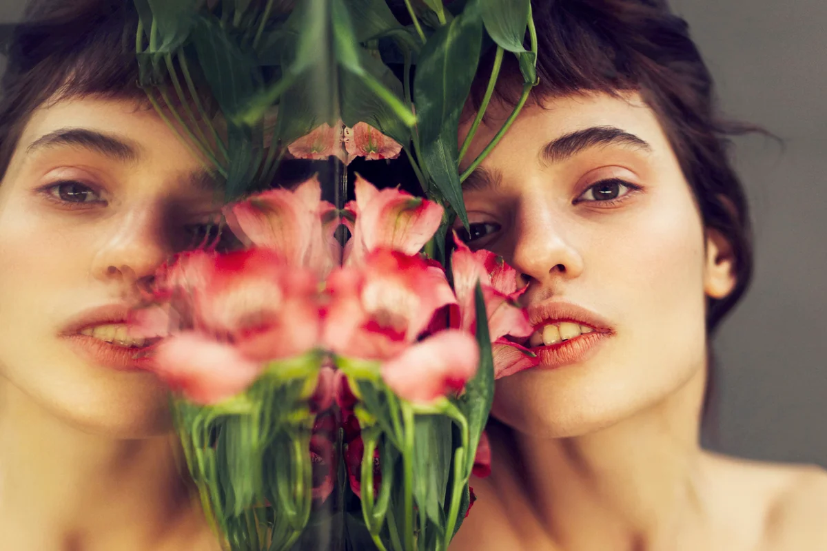 Young pensive woman reflected in mirror