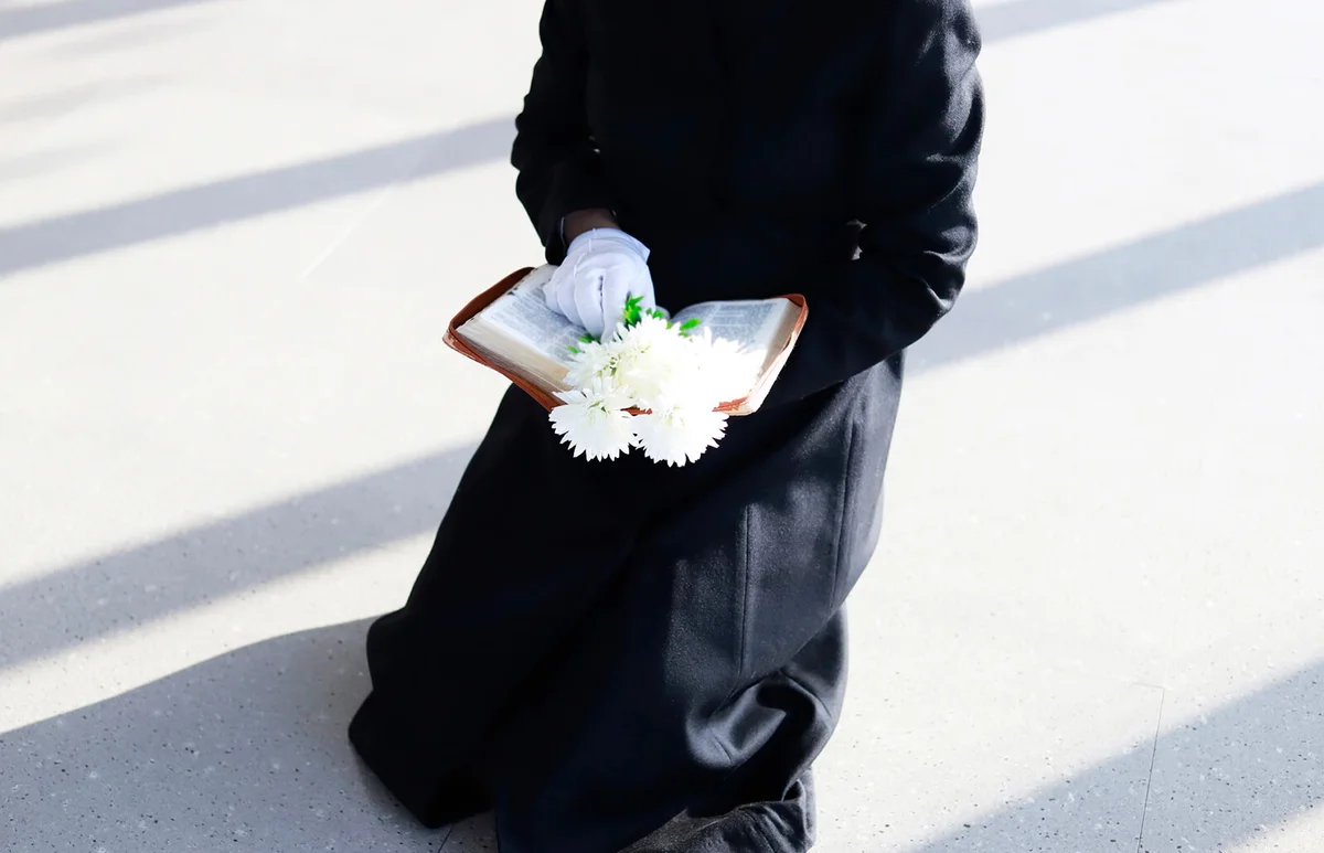 Sadness bereaved holding bible and white flower