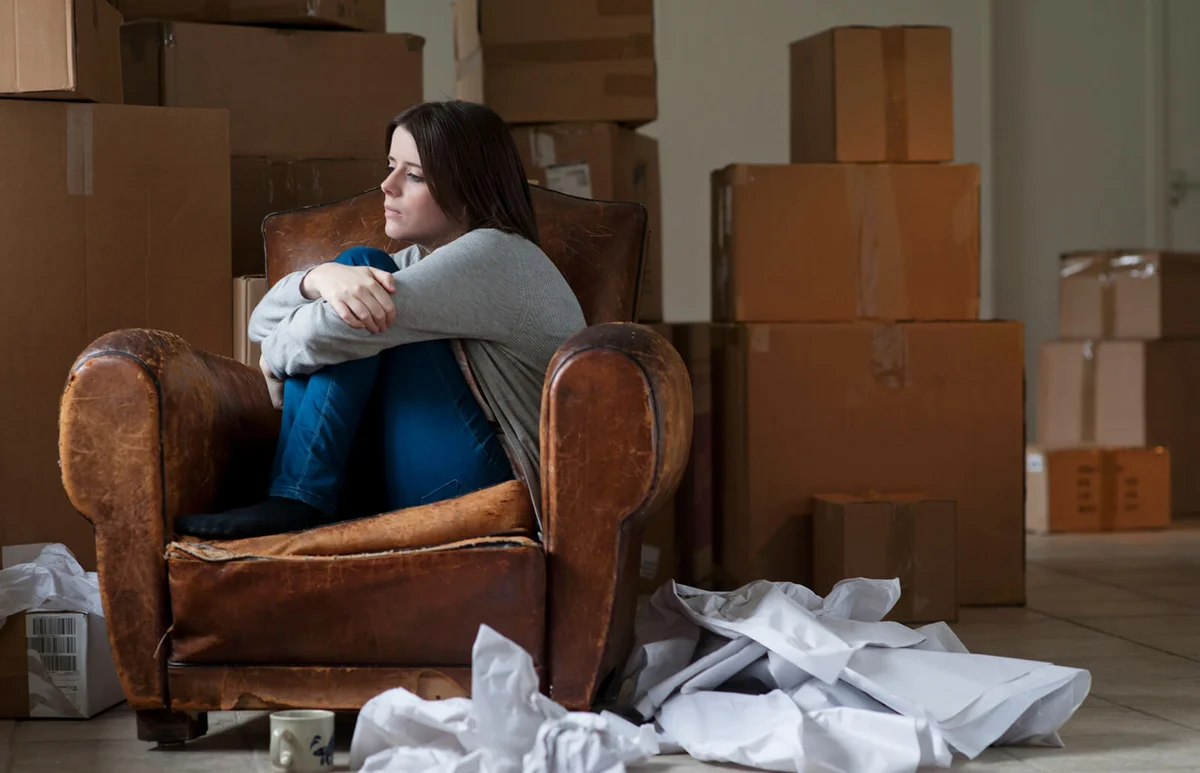 Sad woman in armchair in new home