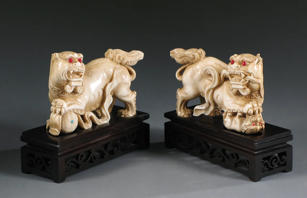 Pair of antique Chinese ivory foo lions on wood plinths, circa 1900