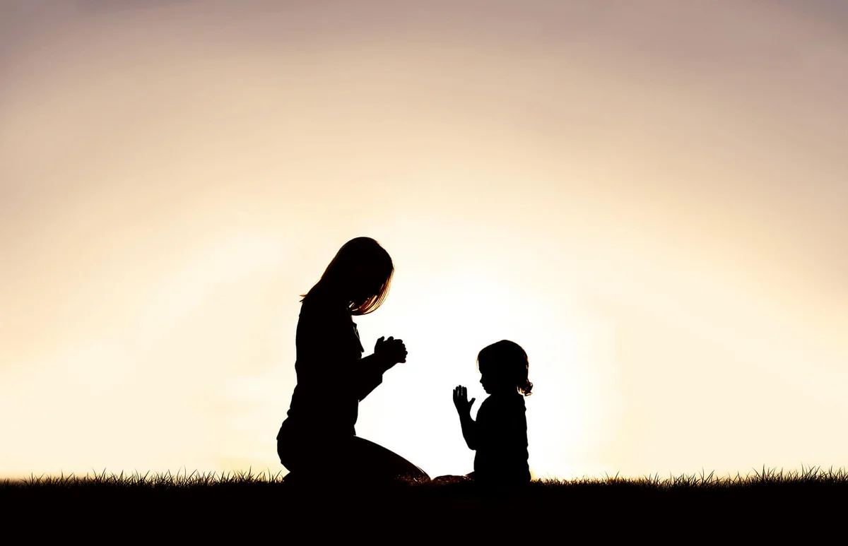 Mother praying with her young child
