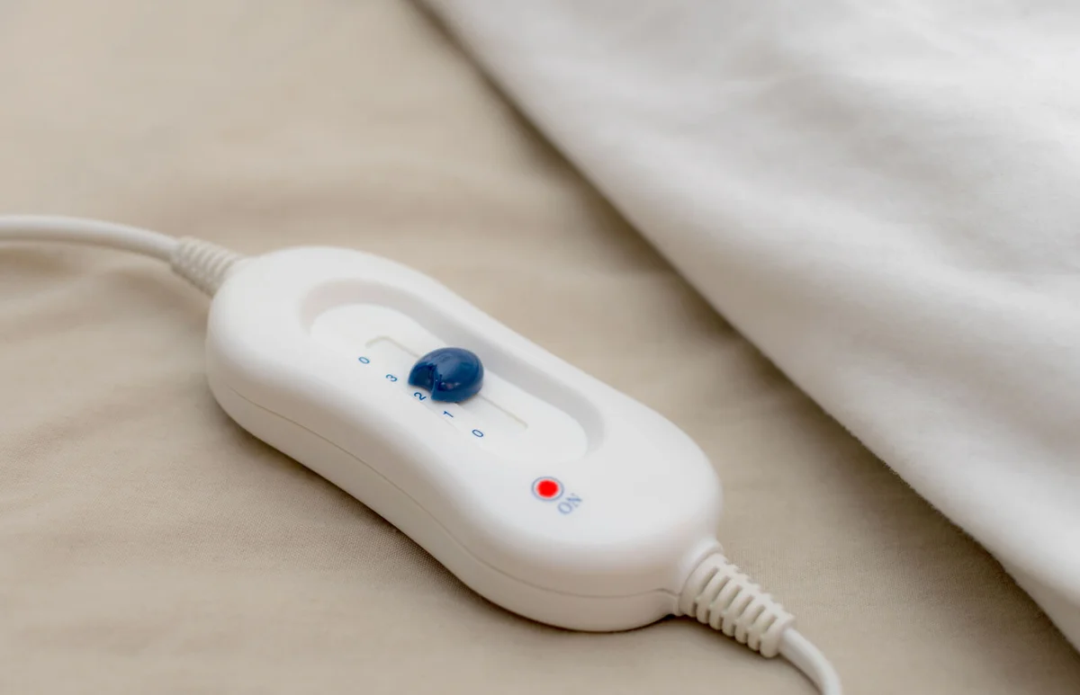 Control button for an electric blanket on a bed