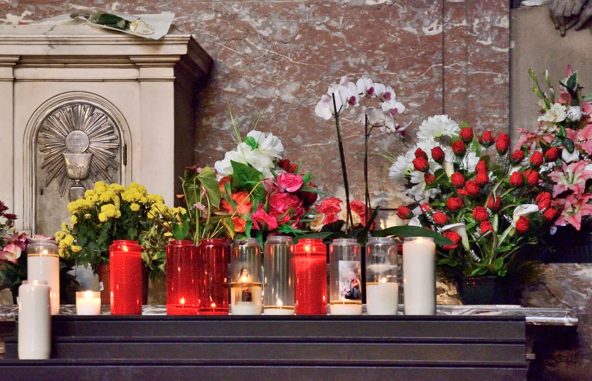 Burning candles and flowers bouquets in a church